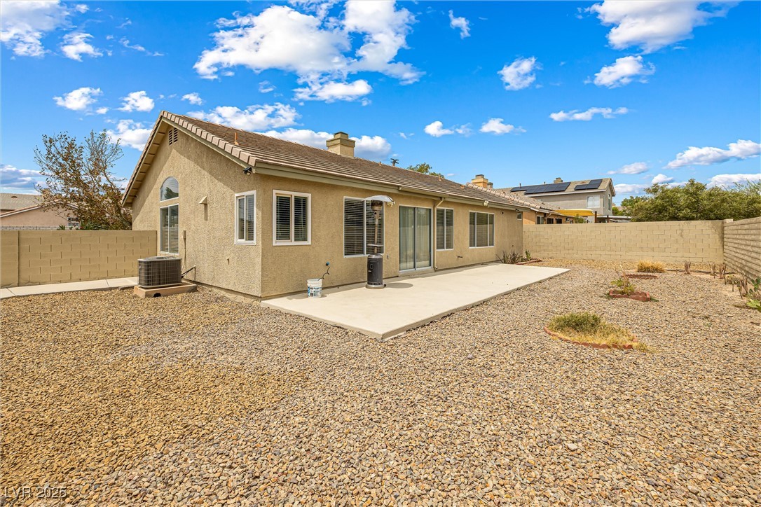8878 Haviland Road Las Vegas, NV 89123 - Photo 39 of 58 Back of house featuring stucco siding, a chimney, a patio area, and a fenced backyard