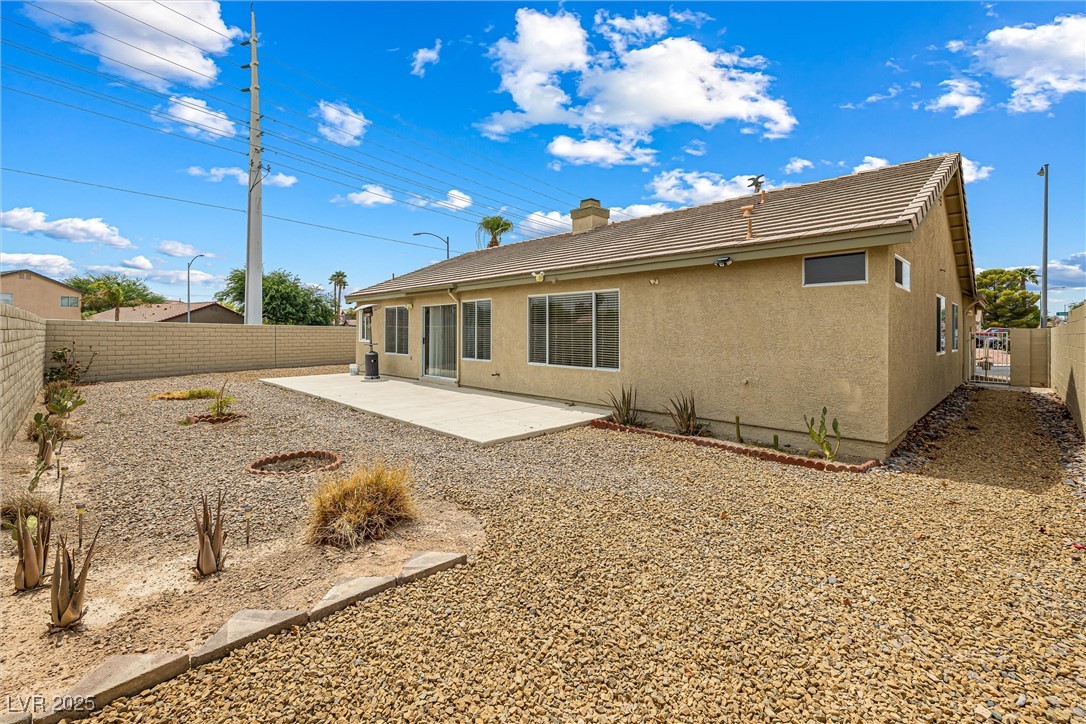 8878 Haviland Road Las Vegas, NV 89123 - Photo 42 of 58 Rear view of house featuring stucco siding, a fenced backyard, a patio area, a tile roof, and a gate