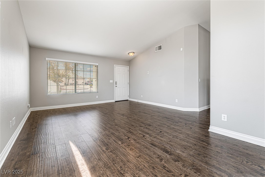 8878 Haviland Road Las Vegas, NV 89123 - Photo 9 of 58 Unfurnished living room with dark wood-style floors and vaulted ceiling