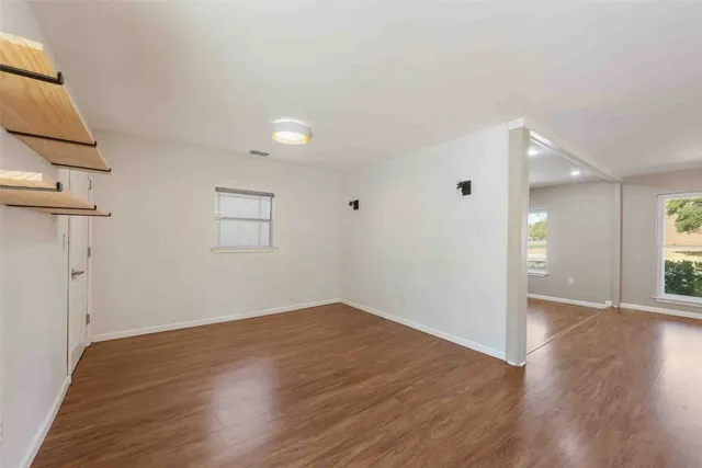 a large kitchen with cabinets wooden floor and stainless steel appliances