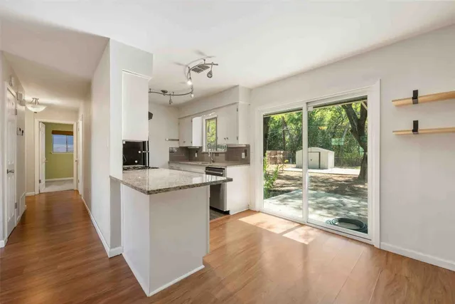 a kitchen with stainless steel appliances kitchen island granite countertop a stove refrigerator and cabinets