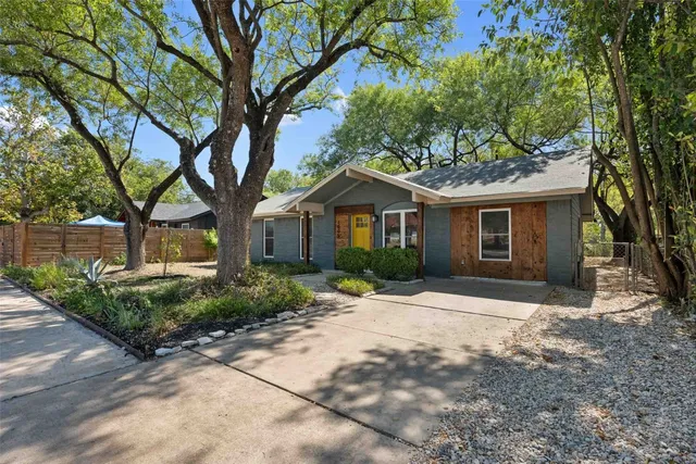 a front view of a house with a yard and potted plants