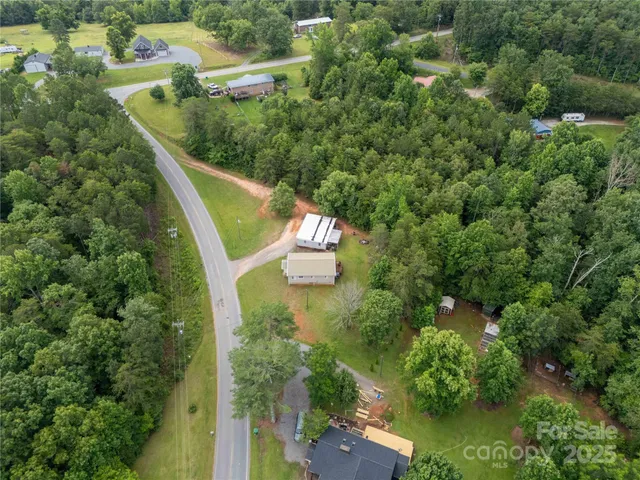 an aerial view of a house with a yard and lake view