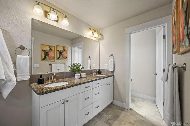 a bathroom with double sink and a mirror
