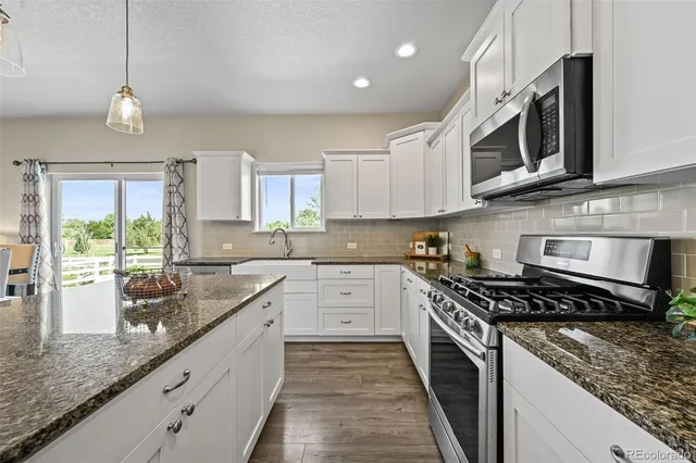 a kitchen with stainless steel appliances granite countertop a sink and stove top oven