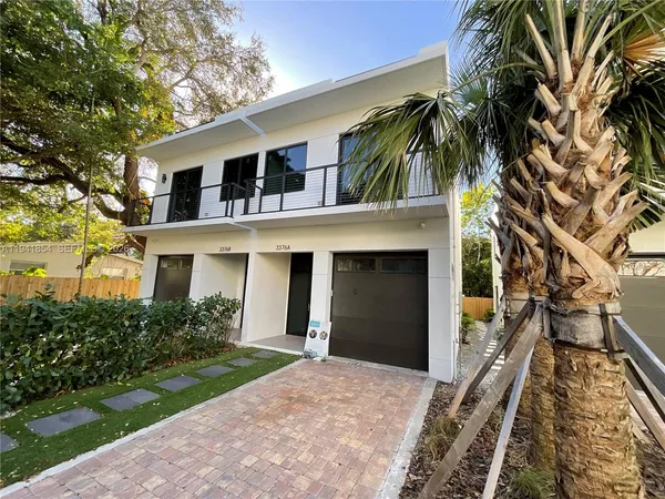 a front view of house with yard and trees around