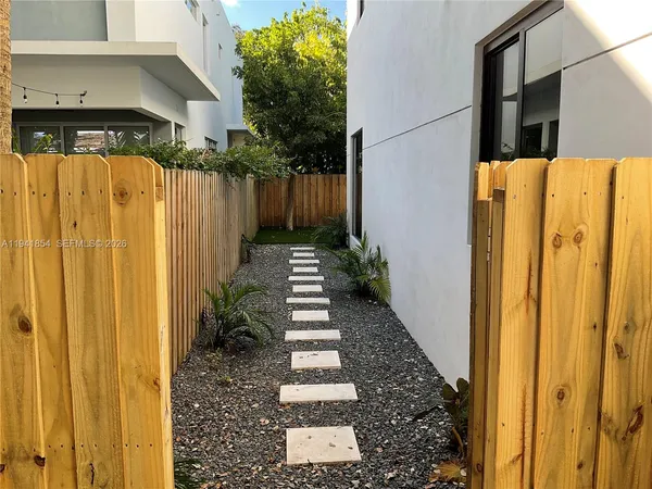 a view of a pathway of a house with wooden fence