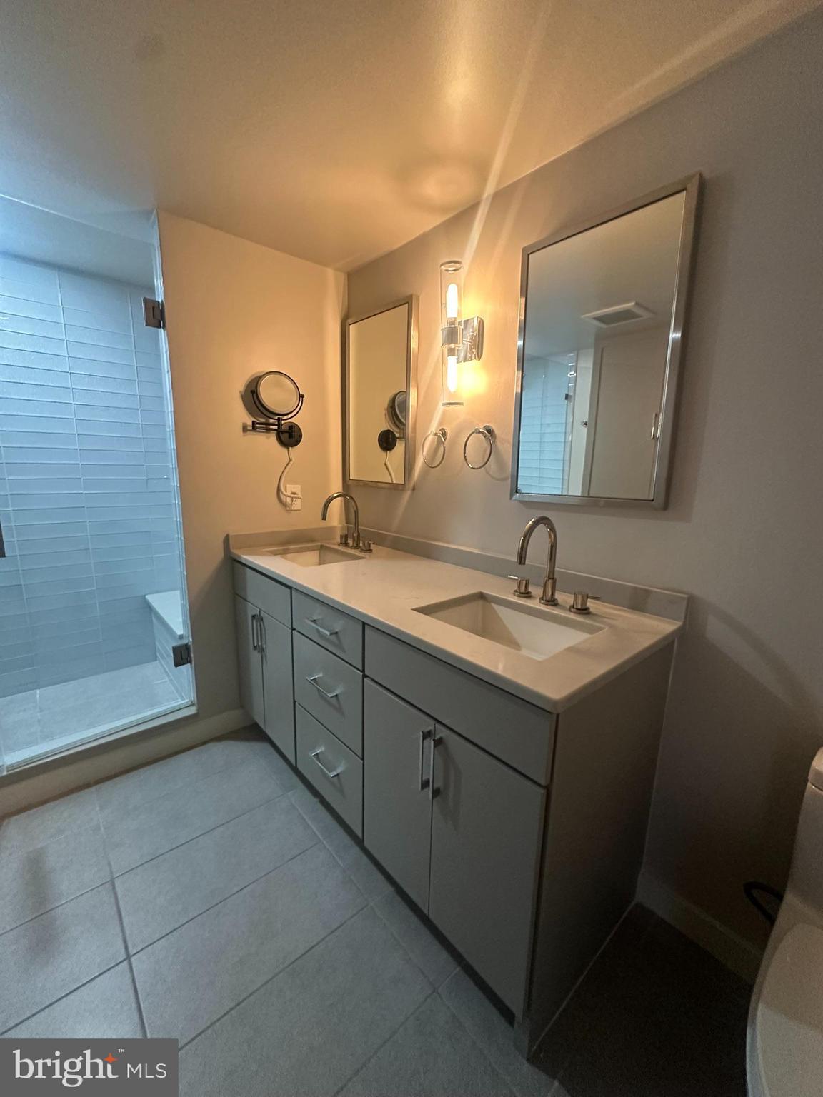 1025 First Street Southeast, Unit 901 Washington, DC 20003 - Photo 25 of 56 a spacious bathroom with a double vanity sink a mirror and a bathtub