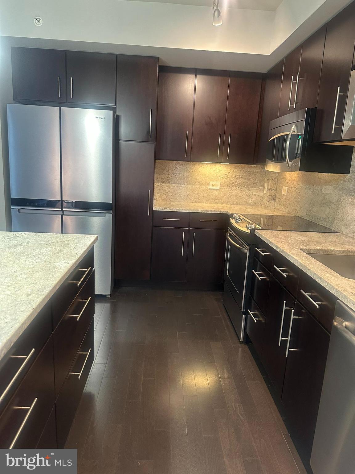 1025 First Street Southeast, Unit 901 Washington, DC 20003 - Photo 35 of 56 a kitchen with stainless steel appliances granite countertop a sink a stove and a refrigerator