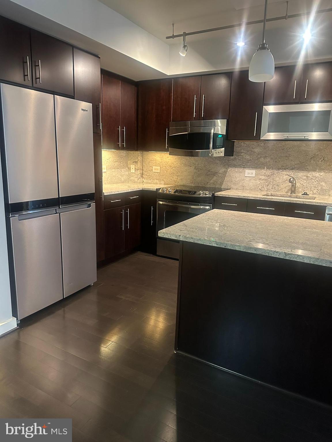 1025 First Street Southeast, Unit 901 Washington, DC 20003 - Photo 8 of 56 a kitchen with stainless steel appliances granite countertop a refrigerator a stove and a sink with wooden floor