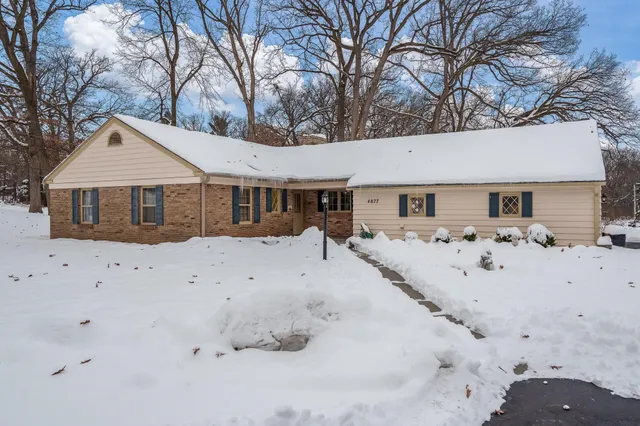 a view of a large white house with a yard covered in snow