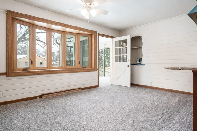 a view of an empty room with a fireplace and a window