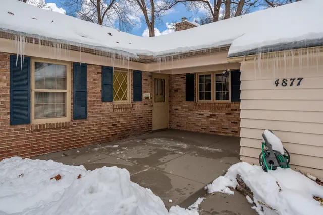 a white house that has a large tree in front of it