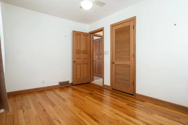 a view of an empty room with a window and brick wall