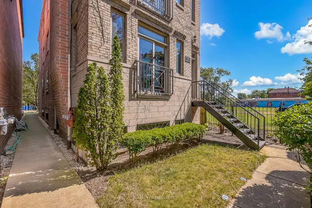 a view of a house with brick walls and flower plants