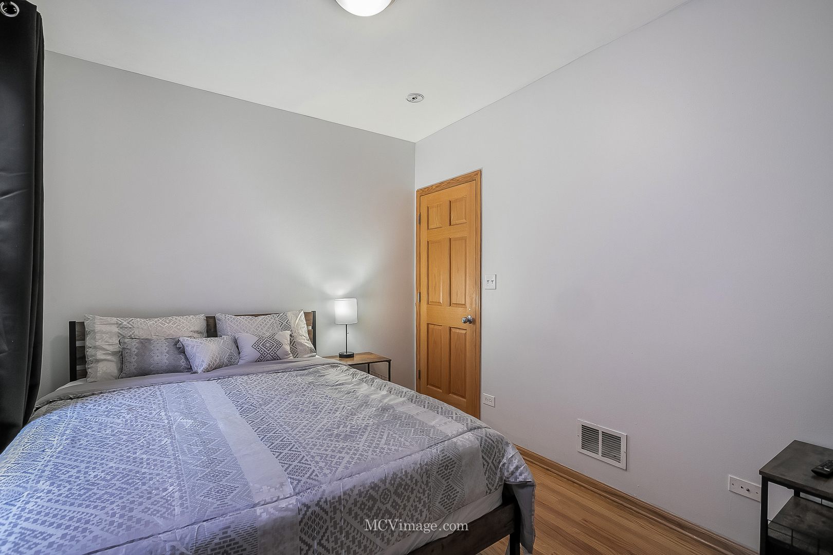 3751 South Michigan Avenue, Unit 2 Chicago, IL 60653 - Photo 6 of 12 a bedroom with a bed and wooden floor