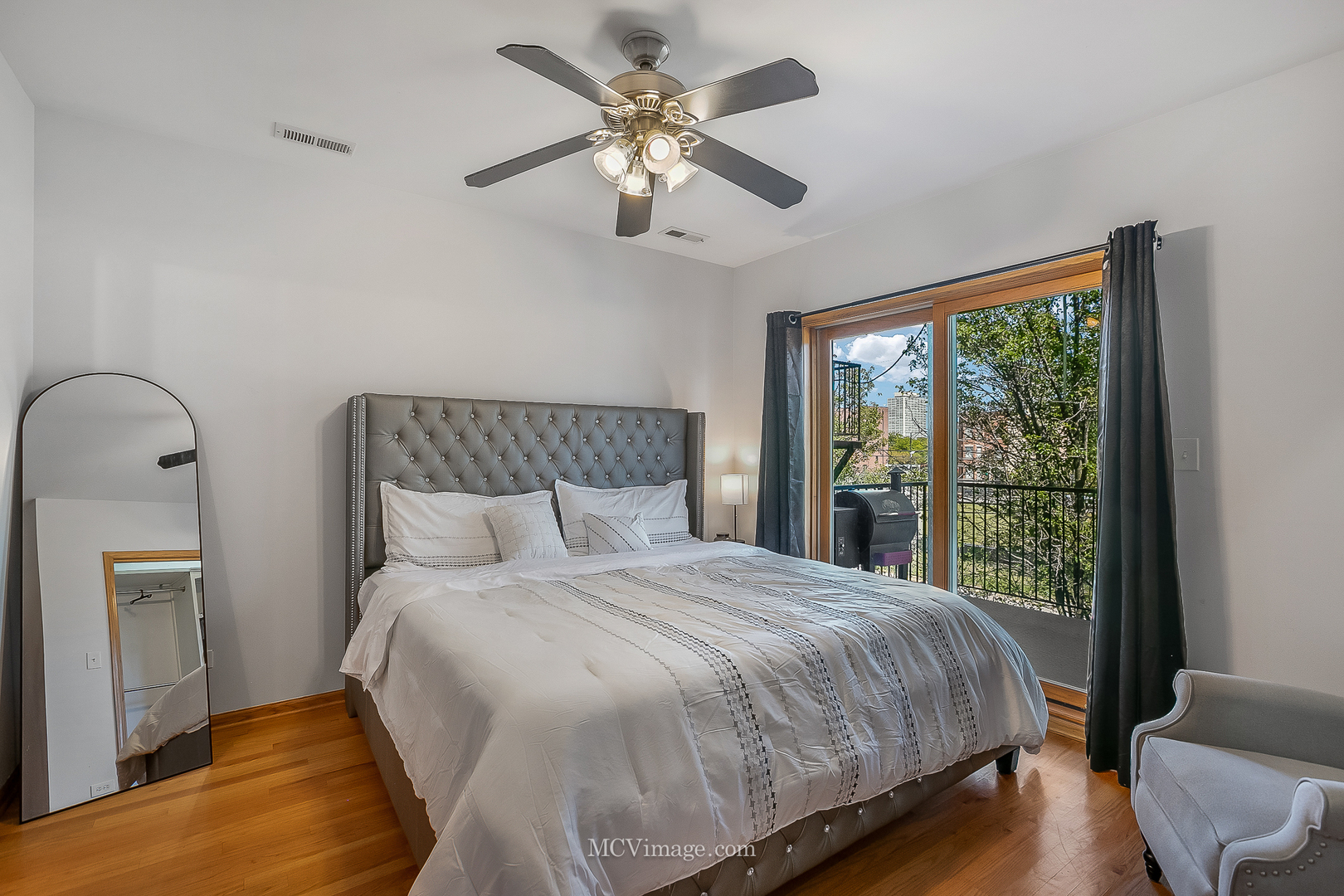 3751 South Michigan Avenue, Unit 2 Chicago, IL 60653 - Photo 7 of 12 a bedroom with a large bed and a chandelier