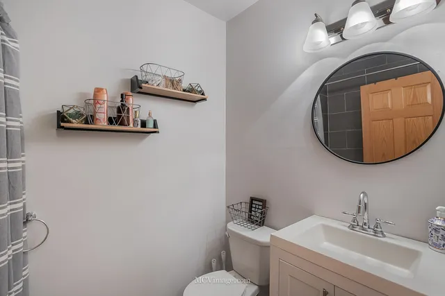 a bathroom with a sink mirror and toilet
