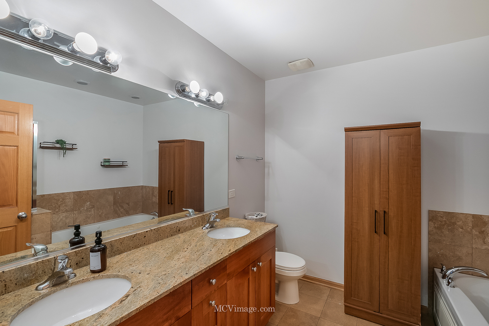 3751 South Michigan Avenue, Unit 2 Chicago, IL 60653 - Photo 9 of 12 a bathroom with a granite countertop sink a toilet and a mirror