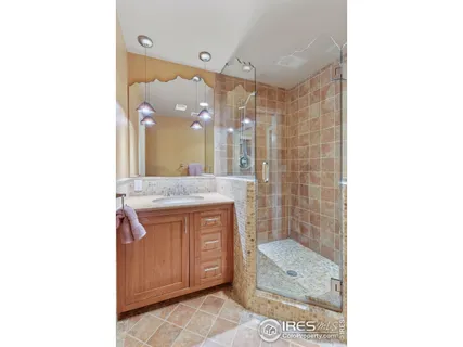 a bathroom with a granite countertop sink a mirror and a shower