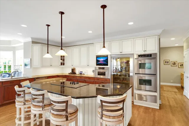 a kitchen with stainless steel appliances granite countertop a sink a counter space and living room view