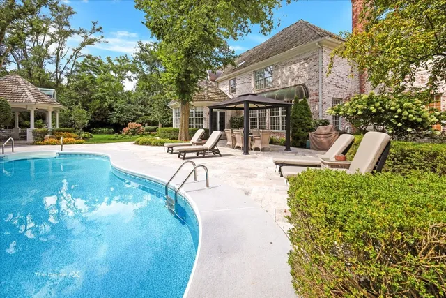 a view of a house with a big yard and large trees