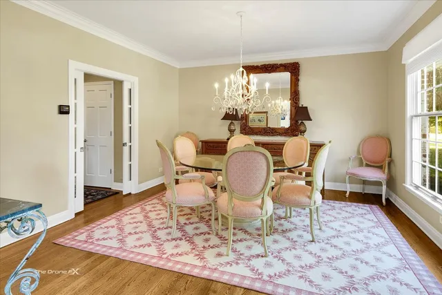 a spacious bedroom with a large bed a chandelier and windows