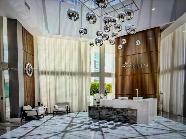 a living room with a large window and chandelier
