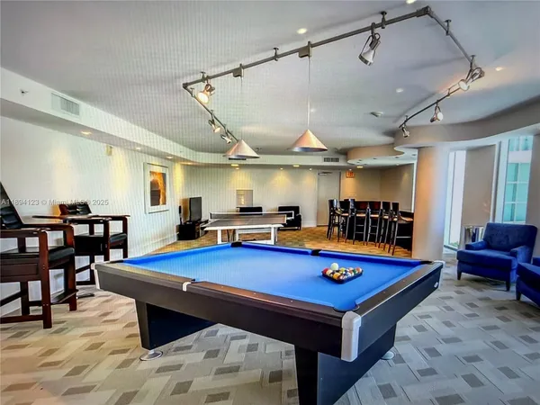 a room with furniture pool table flat screen tv and a rug
