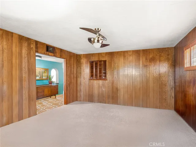 a view of a hallway with a chandelier fan and wooden floor