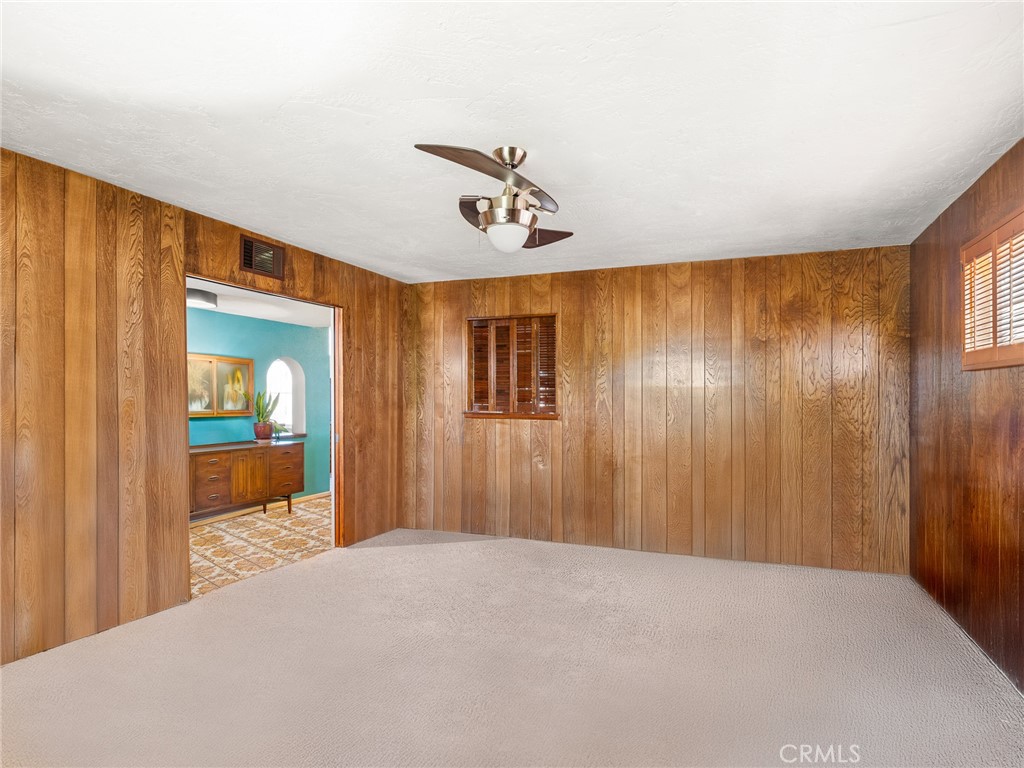 13916 Burning Tree Drive Victorville, CA 92395 - Photo 16 of 49 a view of a hallway with a chandelier fan and wooden floor