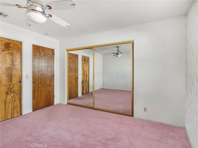 a bedroom with a bed and a chandelier fan