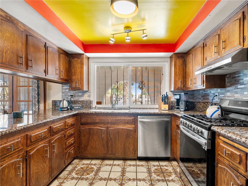 13916 Burning Tree Drive Victorville, CA 92395 - Photo 21 of 49 a kitchen with a sink and a stove