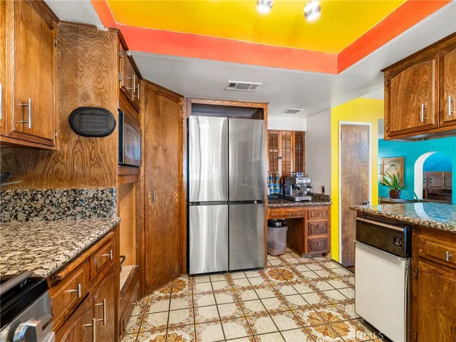 a kitchen with stainless steel appliances granite countertop a refrigerator and a stove