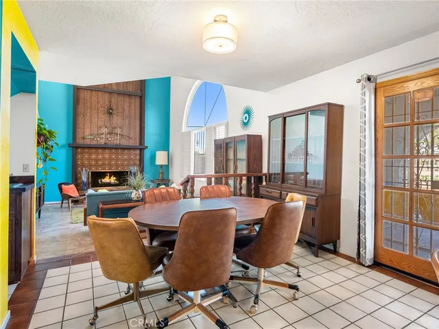 a living room with furniture a fireplace and a floor to ceiling window