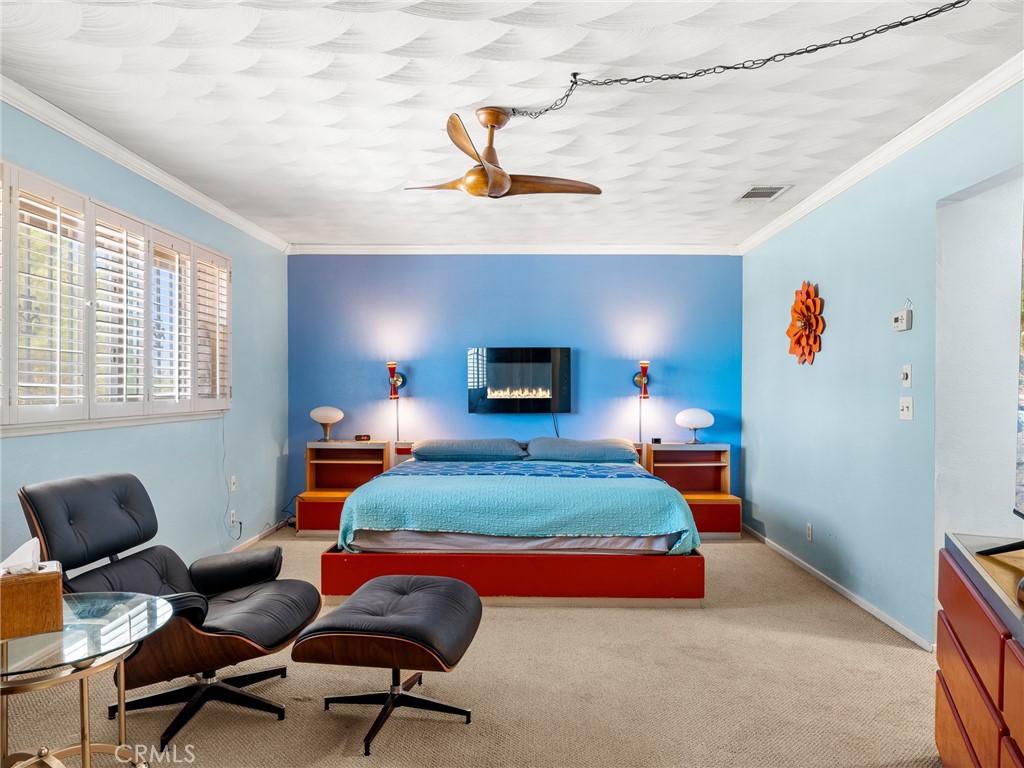 13916 Burning Tree Drive Victorville, CA 92395 - Photo 32 of 49 a bedroom with a bed and a chandelier