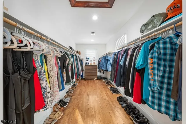 a view of walk in closet with clothes and shoes