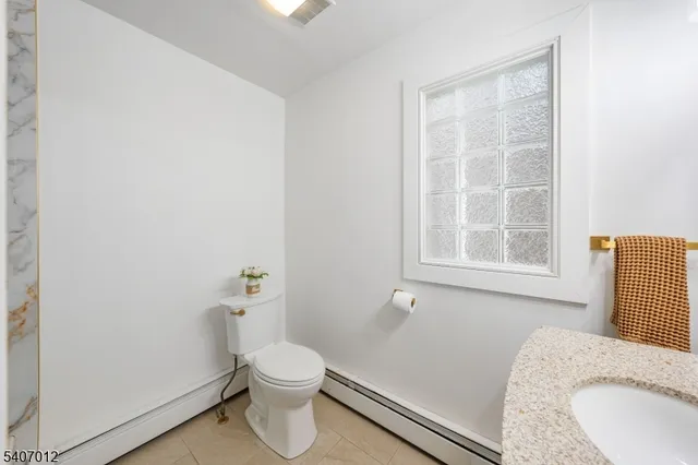 a bathroom with a granite countertop toilet and a sink