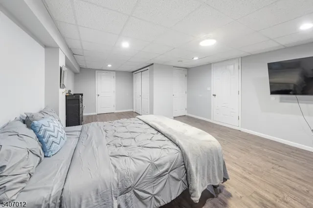 a spacious bedroom with a bed and a flat screen tv