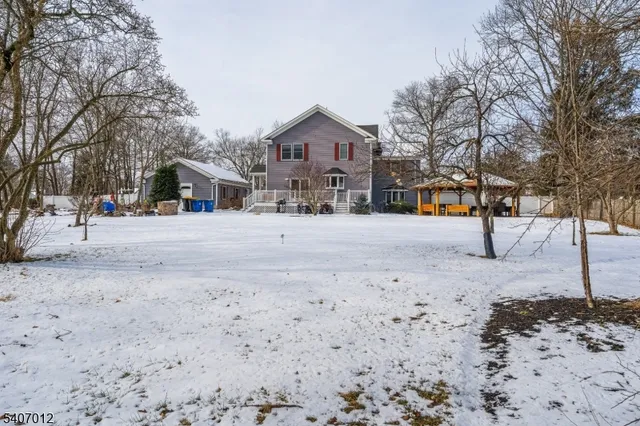 a front view of a house with a yard covered with snow