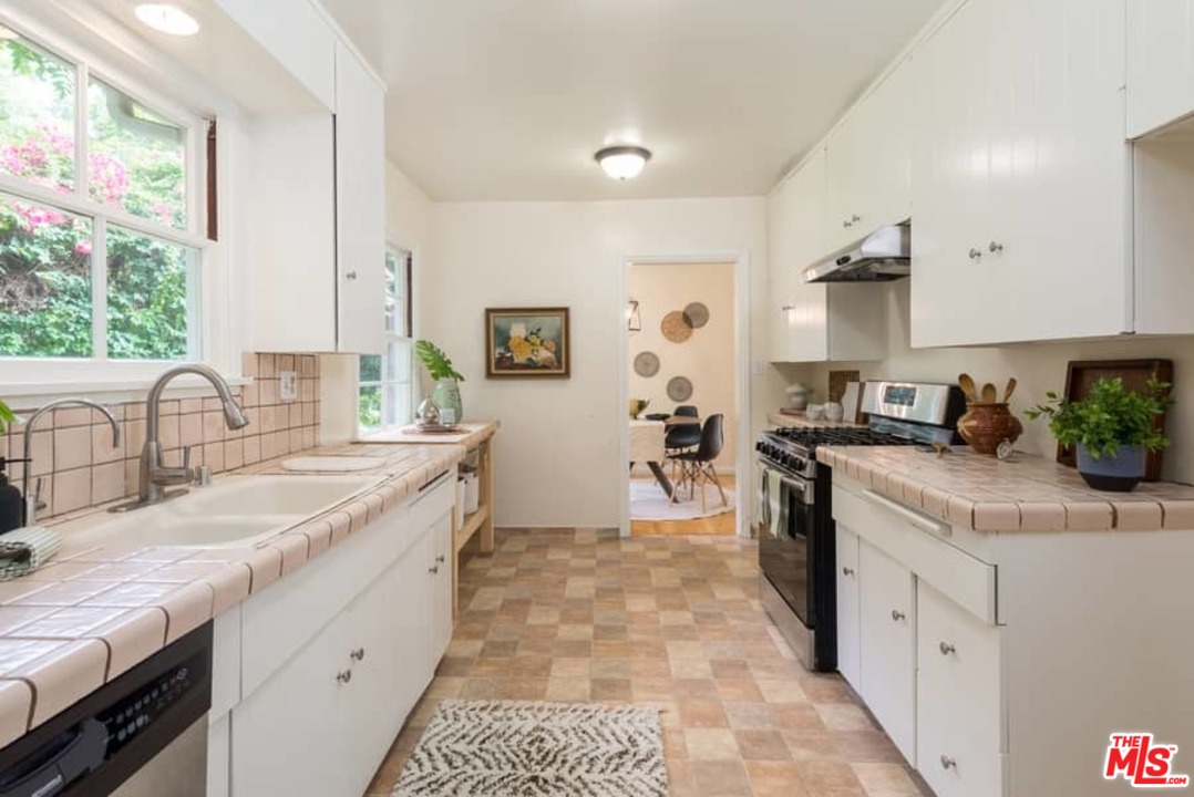 5712 Tellefson Road Culver City, CA 90230 - Photo 10 of 25 a kitchen with granite countertop a sink stove and cabinets