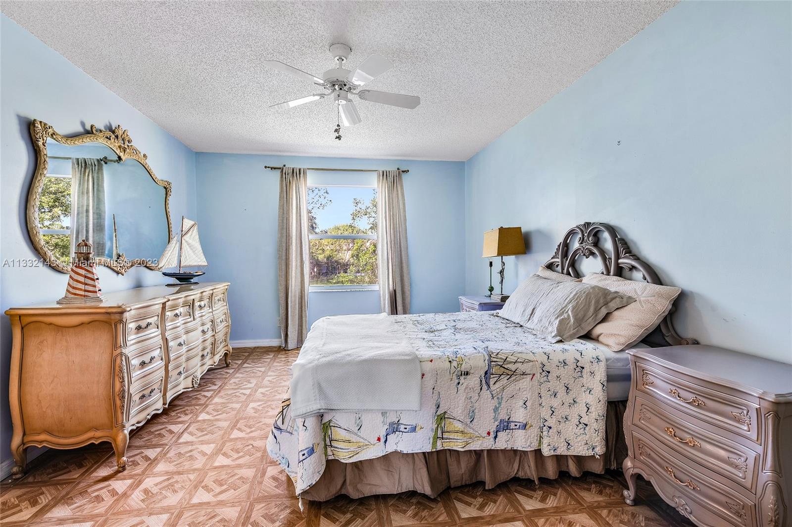 232 Timberwalk Trail Jupiter, FL 33458 - Photo 12 of 33 a bedroom with a bed a mirror on dresser and a chandelier