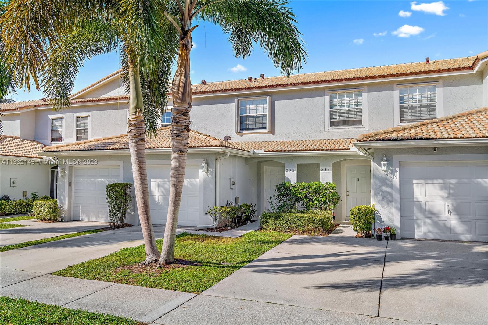 232 Timberwalk Trail Jupiter, FL 33458 - Photo 2 of 33 a front view of a house with a garden