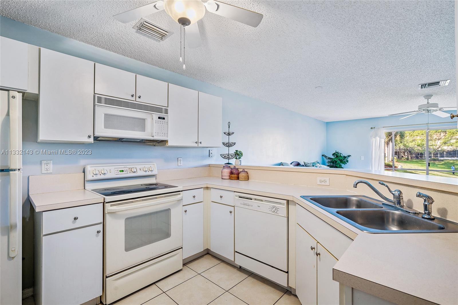 232 Timberwalk Trail Jupiter, FL 33458 - Photo 7 of 33 a white kitchen with stainless steel appliances granite countertop white cabinets a sink and dishwasher