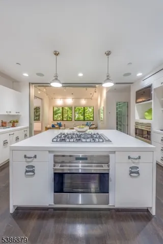 a kitchen with kitchen island a stove and a wooden floor