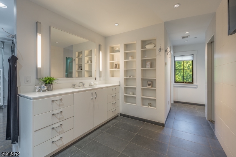 60 Fernwood Road Summit, NJ 07901 - Photo 29 of 50 a bathroom with a double vanity sink a mirror a window and a bathtub