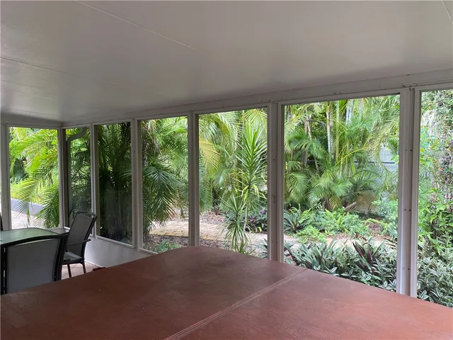 a bedroom with a bed and large windows