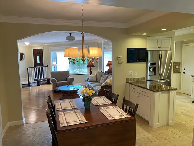 a living room with furniture a flat screen tv and floor to ceiling window