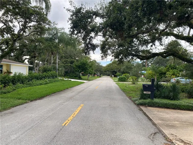a front view of a house with yard and tree