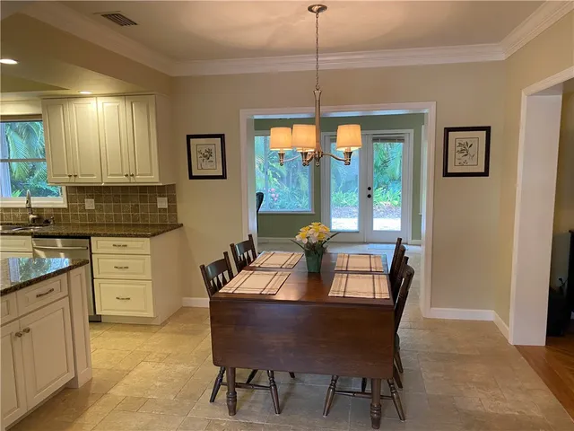 a dining room with furniture a chandelier and window